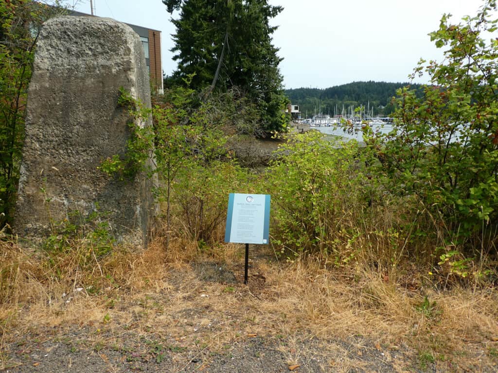 A turquoise poetry plaque stands along a trail near Donkey Creek in Gig Harbor.