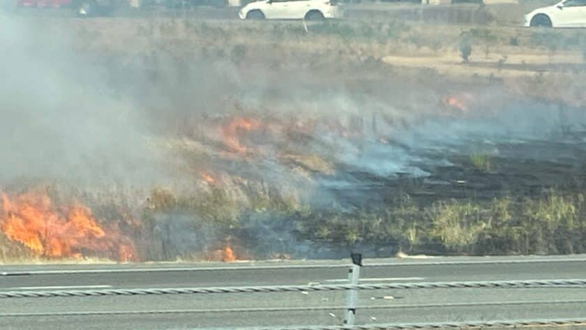 A brush fire burns Tuesday between Highway 16 and the Wollochet Drive ramp.