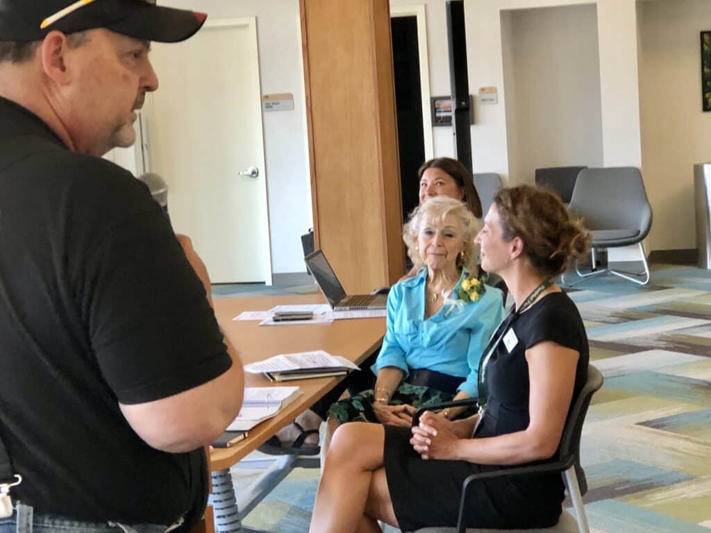 BBQ2U owner and senior supporter Gary Parker lauds Betty Lilienthal's accomplishments. PenMet Executive Director Ally Bujacich is on the right.